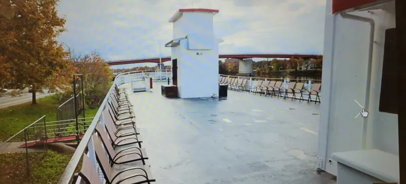Slide: The Image of Upper deck of a 1985 custom passenger boat with chairs and scenic river view. - 5