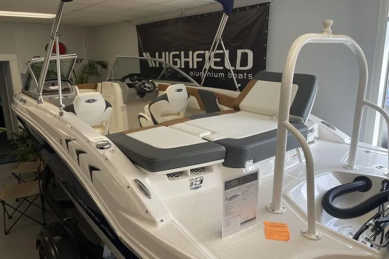 Slide: The Image of 2024 Chaparral 19 SSi OB boat displayed indoors, featuring sleek seating and modern design. - 5