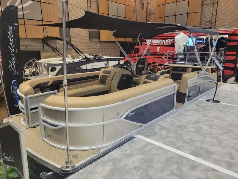 Slide: The Image of 2025 Barletta C24U pontoon boat on display at indoor boat show. - 1