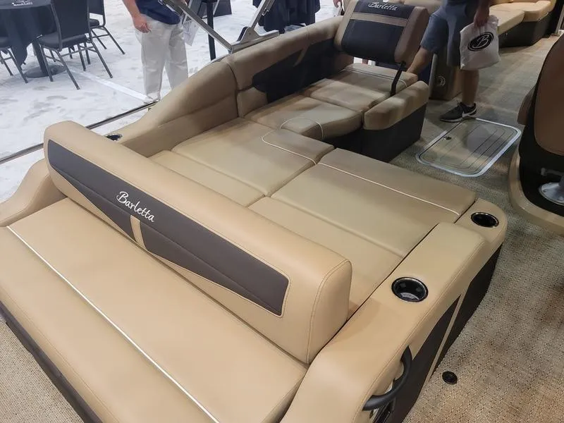 Slide: The Image of 2025 Barletta C24U pontoon boat interior with beige seating and cup holders. - 10