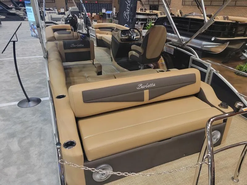 Slide: The Image of 2025 Barletta C24U pontoon boat with luxurious tan seating and modern helm. - 11