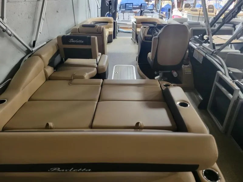 Slide: The Image of 2025 Barletta C24U pontoon boat interior with tan seating and modern design. - 23