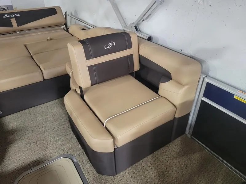 Slide: The Image of 2025 Barletta C24U pontoon boat interior with beige and brown seating. - 25