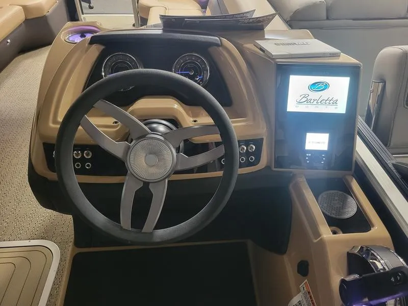 Slide: The Image of 2025 Barletta C24U boat dashboard with steering wheel and digital display. - 26