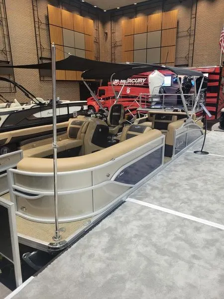 Slide: The Image of 2025 Barletta C24U pontoon boat displayed indoors with beige seating and modern design. - 5