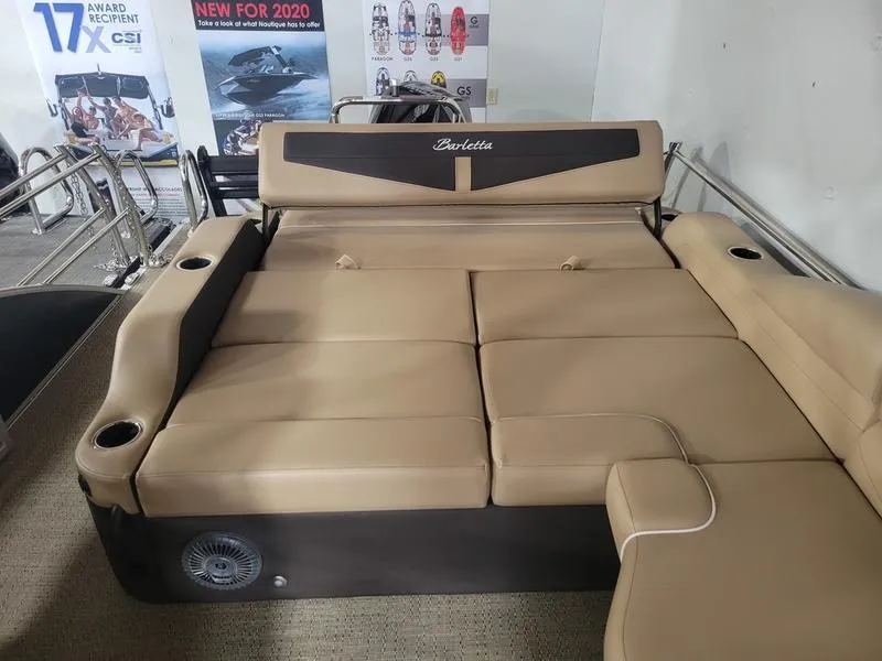 Slide: The Image of 2025 Barletta C24U boat interior with beige seating and cup holders. - 6