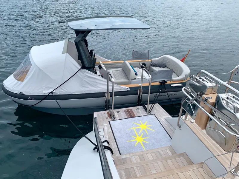 Slide: The Image of Carbon Craft CC 160 boat, 2016 model, docked beside a yacht on calm water. - 4