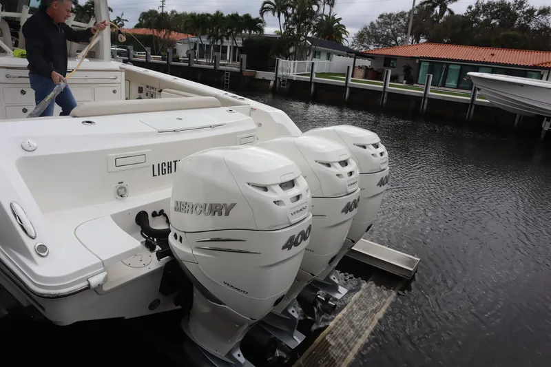 Slide: The Image of 2022 Boston Whaler 380 Outrage with triple Mercury 400 engines docked by waterfront homes. - 11