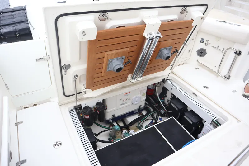 Slide: The Image of 2022 Boston Whaler 380 Outrage engine compartment with open hatch, showcasing mechanical components. - 17