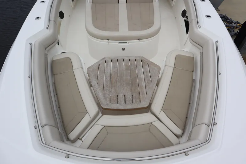 Slide: The Image of Boston Whaler 380 Outrage 2022 boat interior with cushioned seating and wooden table. - 28