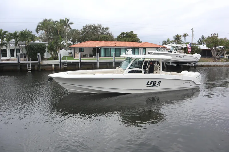 Slide: The Image of 2022 Boston Whaler 380 Outrage boat docked near waterfront homes. - 3