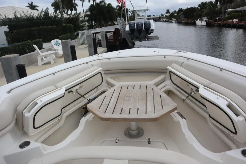 Slide: The Image of 2022 Boston Whaler 380 Outrage boat with spacious seating and wooden table. - 30