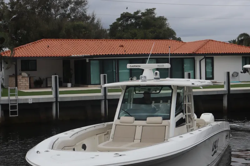 Slide: The Image of 2022 Boston Whaler 380 Outrage boat docked near waterfront home. - 4
