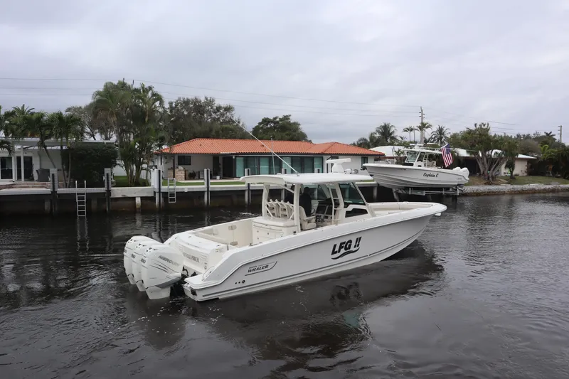 Slide: The Image of 2022 Boston Whaler 380 Outrage boat on a calm waterway near residential docks. - 7
