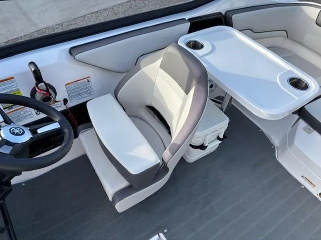 Slide: The Image of 2020 Yamaha Boats SX190 interior with steering wheel, cushioned seat, and table. - 12