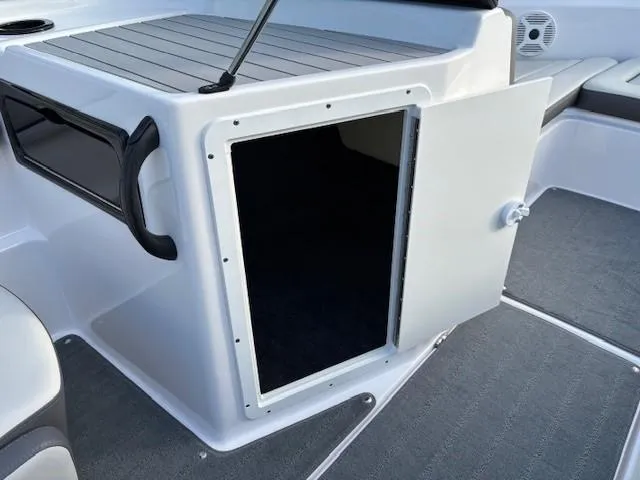 Slide: The Image of 2020 Yamaha Boats SX190 storage compartment with open door, showcasing interior space. - 17