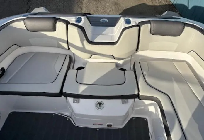 Slide: The Image of 2020 Yamaha Boats SX190 interior seating area with cushioned seats and storage. - 25