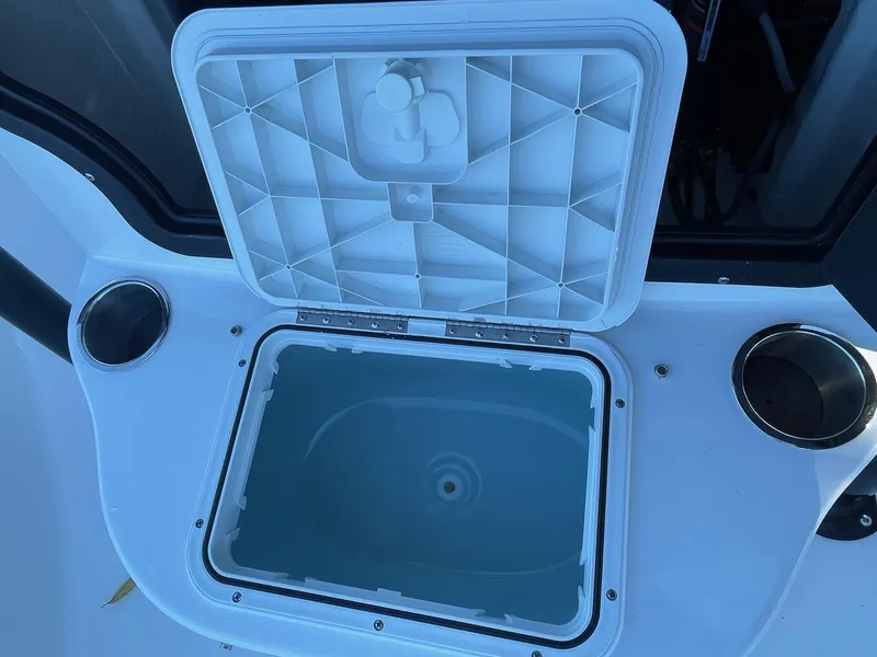 Slide: The Image of Open storage compartment on 2025 Sea Pro 210 DLX boat with cup holders. - 21