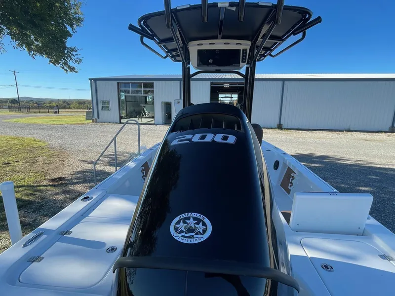 Slide: The Image of 2025 Sea Pro 210 DLX boat with 200 HP engine, parked near a building. - 3