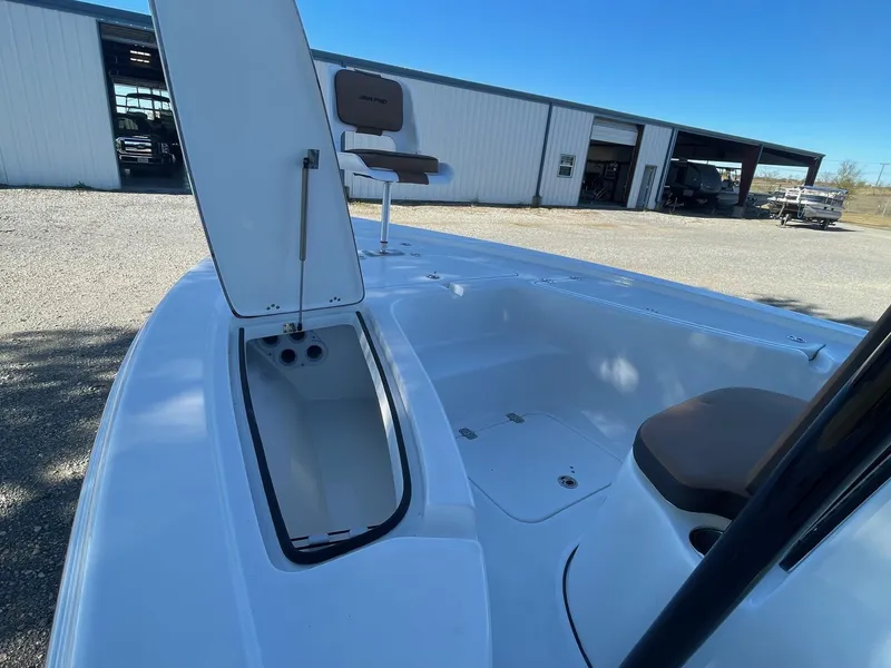 Slide: The Image of 2025 Sea Pro 210 DLX boat with open storage compartment, outdoor setting. - 5