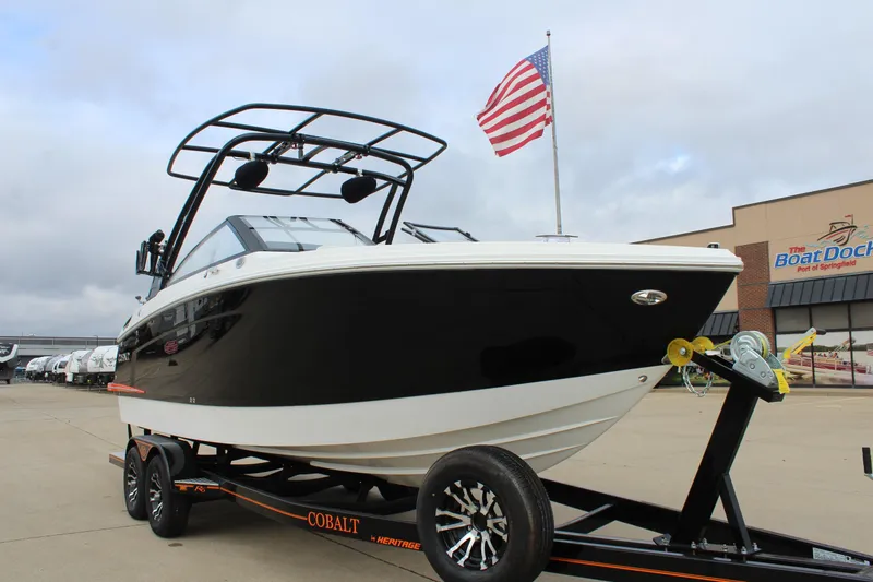 Slide: The Image of 2024 Cobalt R6 boat on trailer with American flag in background. - 2