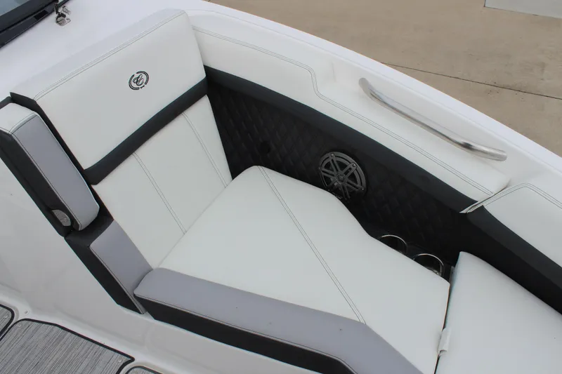 Slide: The Image of 2024 Cobalt R6 boat interior with white and gray seating, featuring a speaker and cup holders. - 29