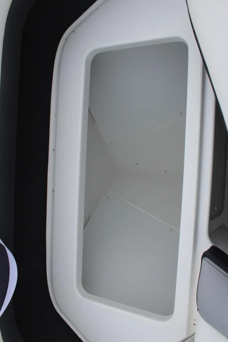 Slide: The Image of 2024 Cobalt R6 boat storage compartment, white interior, close-up view. - 33