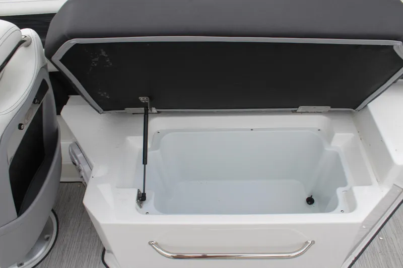 Slide: The Image of 2024 Cobalt R6 boat storage compartment with open lid and cushioned seat. - 35