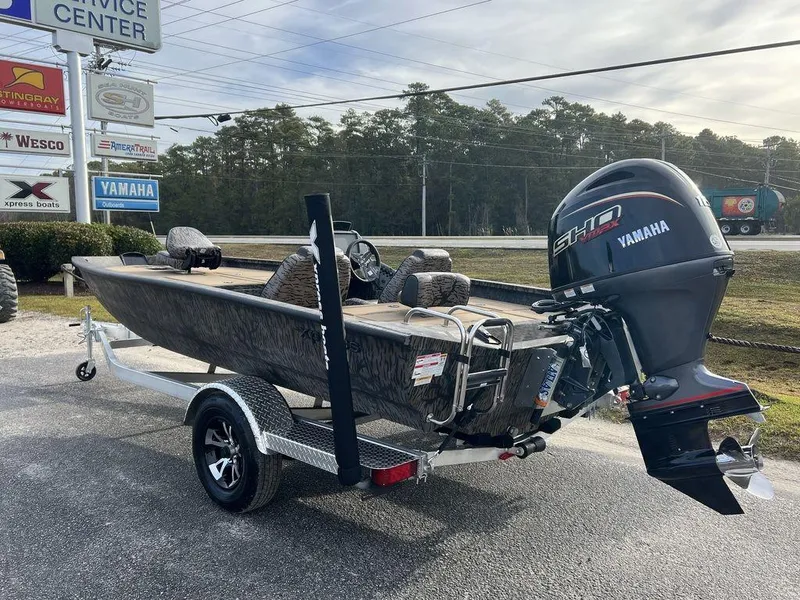 Slide: The Image of 2025 Xpress H18 Bass boat with Yamaha engine on trailer, parked outdoors. - 3
