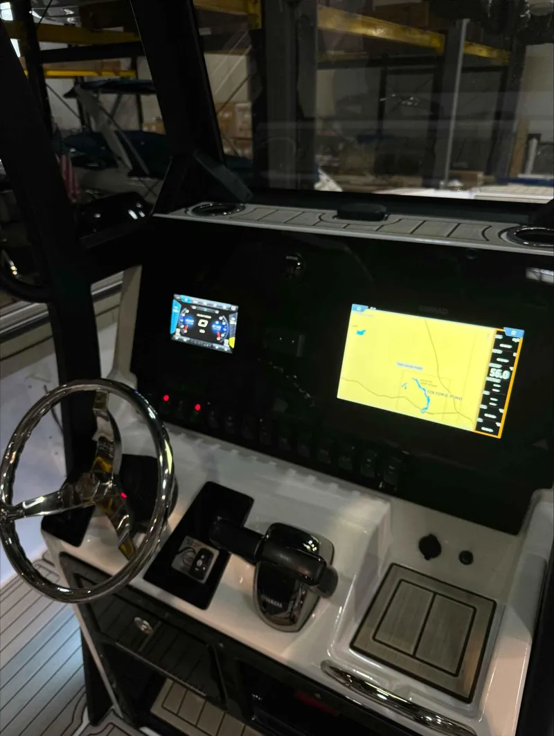 Slide: The Image of 2023 Yamaha Boats 255FSH SPORT E dashboard with navigation screens and steering wheel. - 10