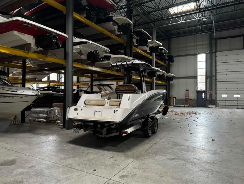 Slide: The Image of 2023 Yamaha Boats 255FSH SPORT E in storage facility, surrounded by other boats. - 3