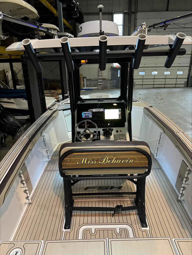 Slide: The Image of 2023 Yamaha Boats 255FSH SPORT E interior with "Miss Behavin" nameplate, docked indoors. - 8
