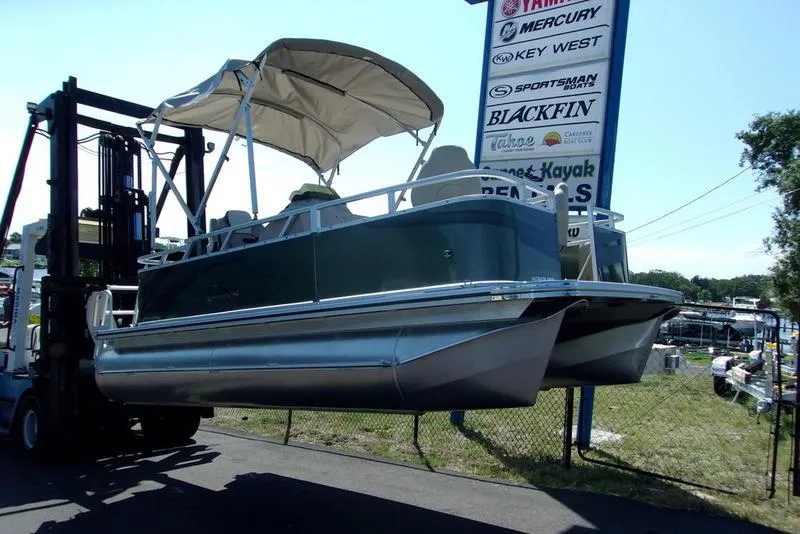 Slide: The Image of 2023 Tahoe Sport Bow 17 FT pontoon boat on forklift near dealership sign. - 3