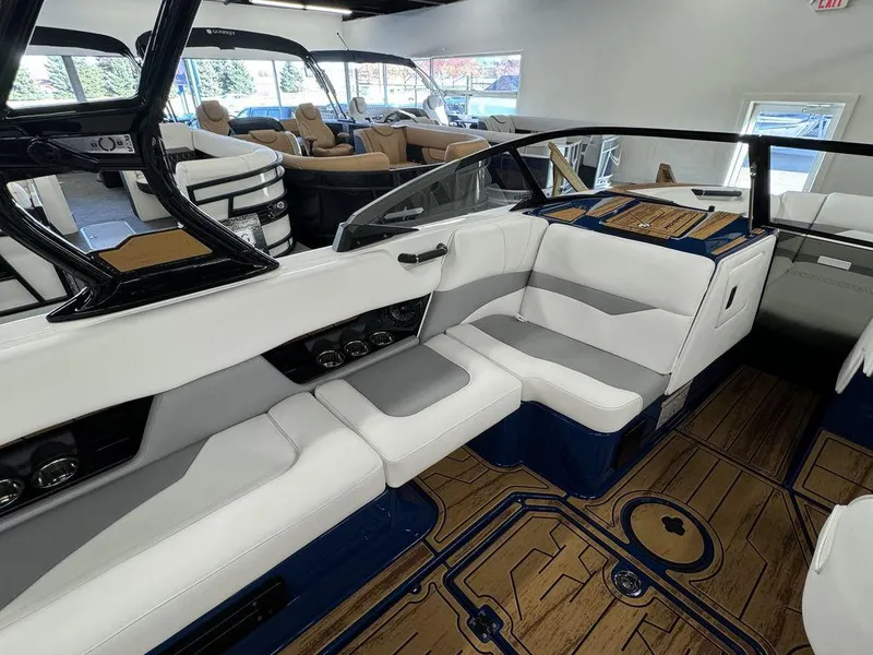 Slide: The Image of 2025 Moomba Mojo boat interior with white and gray seating, wood flooring, and modern design. - 1