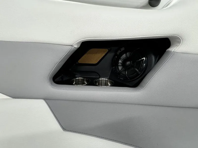 Slide: The Image of 2025 Moomba Mojo interior speaker and cup holders in white and gray upholstery. - 10