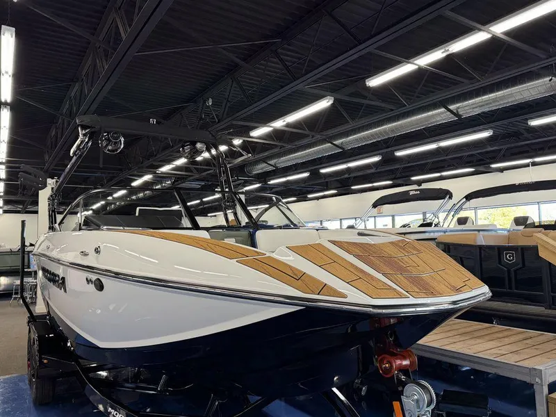 Slide: The Image of 2025 Moomba Mojo boat with sleek design in showroom setting. - 12