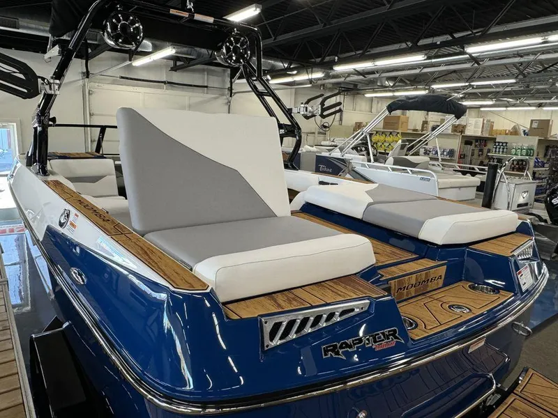 Slide: The Image of 2025 Moomba Mojo boat with sleek design and comfortable seating in showroom. - 14