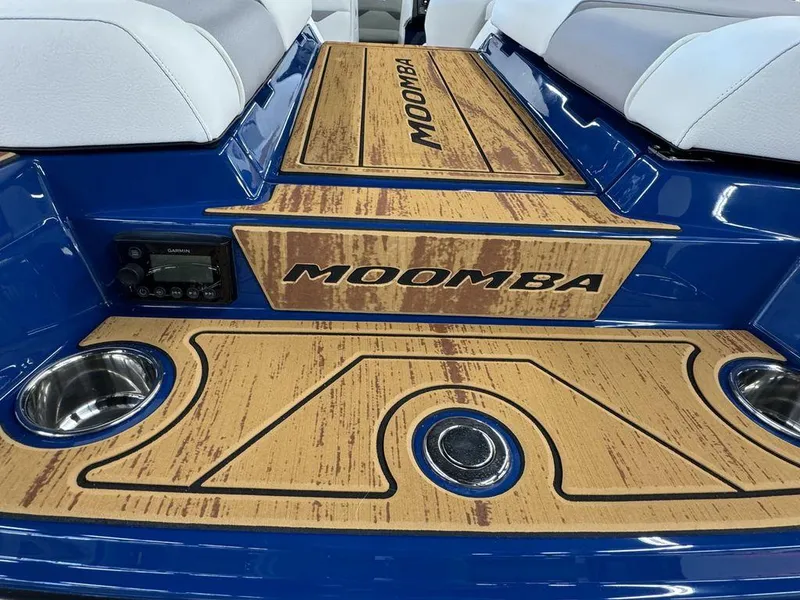 Slide: The Image of 2025 Moomba Mojo boat interior with custom wood paneling and cup holders. - 16