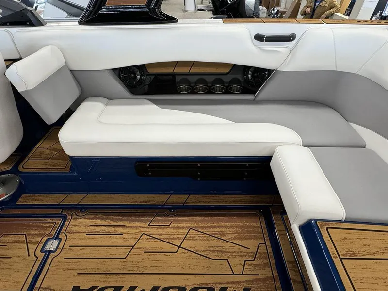 Slide: The Image of 2025 Moomba Mojo boat interior with white and gray seating, wood-patterned flooring. - 19