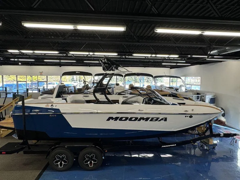 Slide: The Image of 2025 Moomba Mojo boat displayed in a showroom, featuring sleek design and modern features. - 2