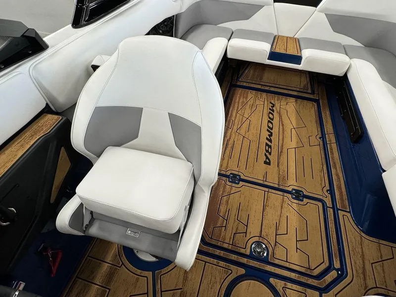 Slide: The Image of 2025 Moomba Mojo boat interior with white seating and custom wood flooring. - 23