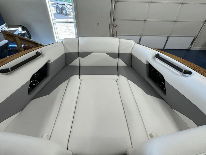 Slide: The Image of 2025 Moomba Mojo boat interior with gray and white seating in a garage setting. - 26