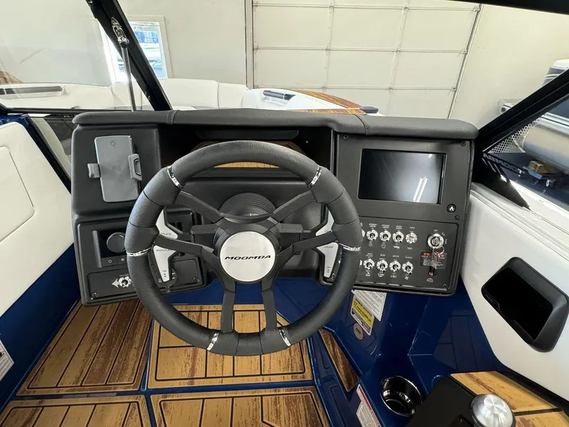 Slide: The Image of 2025 Moomba Mojo boat dashboard with steering wheel and control panel. - 7