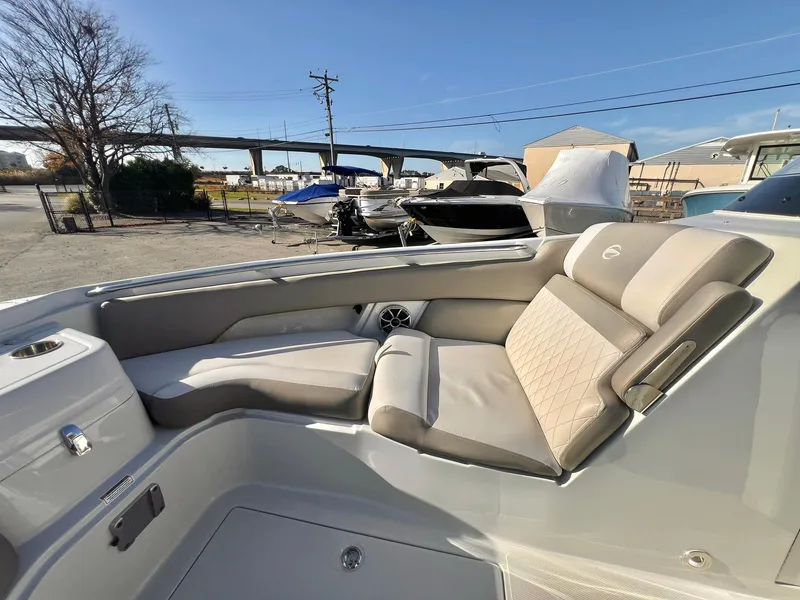 Slide: The Image of 2025 Crownline 280 DC boat with luxurious seating in a marina setting. - 15