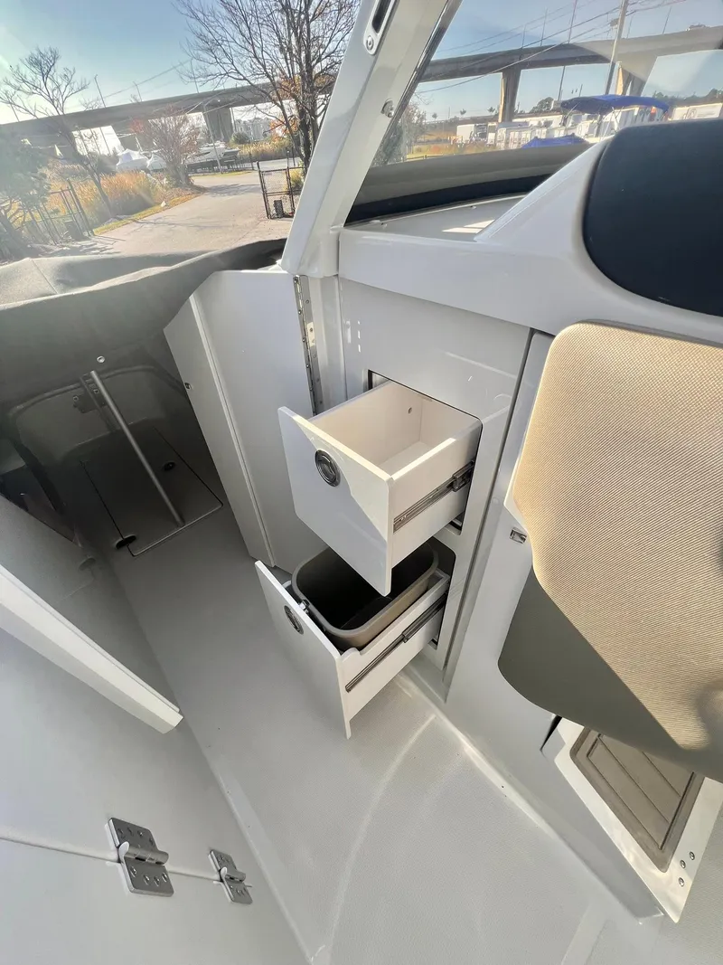 Slide: The Image of Interior of 2025 Crownline 280 DC boat with open storage compartments. - 21