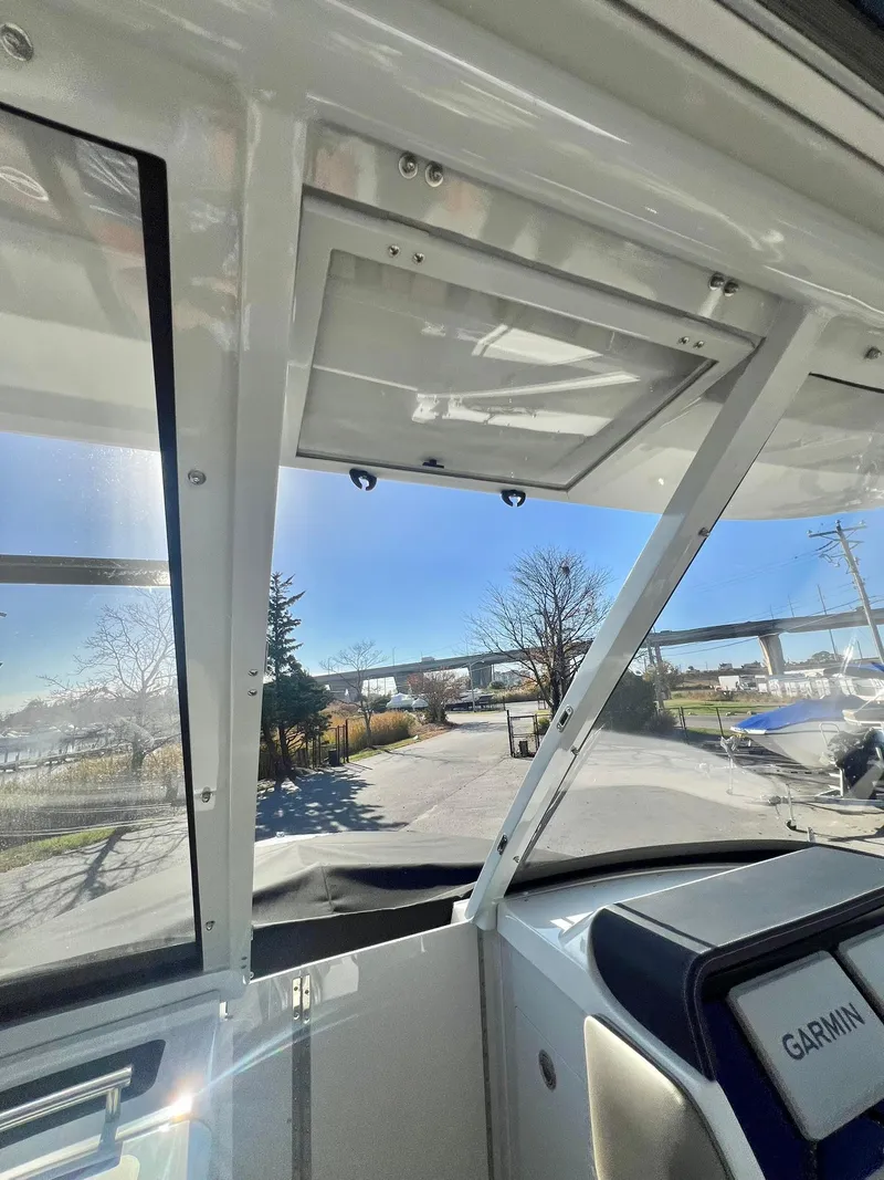 Slide: The Image of Interior view of 2025 Crownline 280 DC boat with clear sky and road in background. - 22