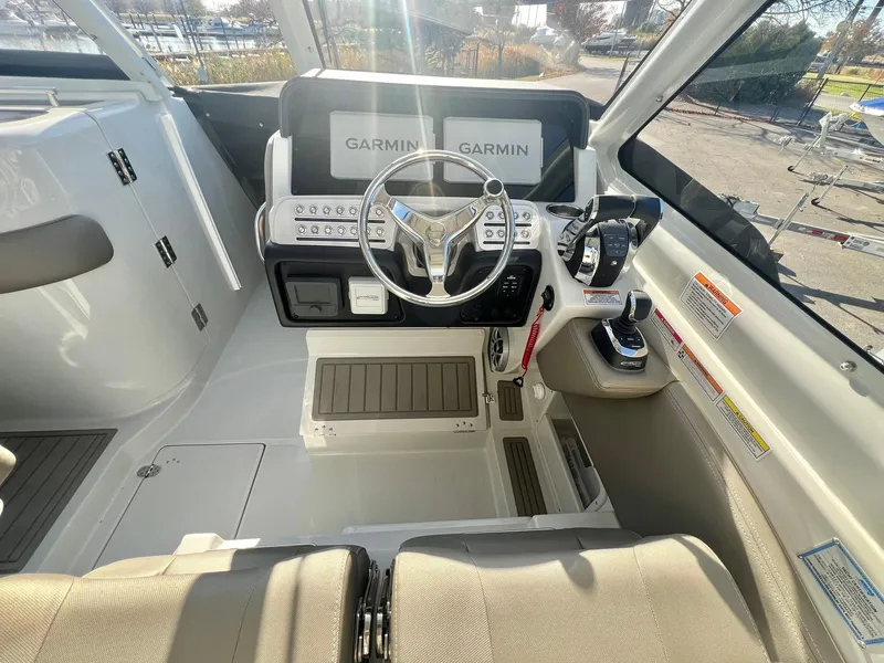 Slide: The Image of 2025 Crownline 280 DC boat cockpit with Garmin navigation system and modern steering wheel. - 28