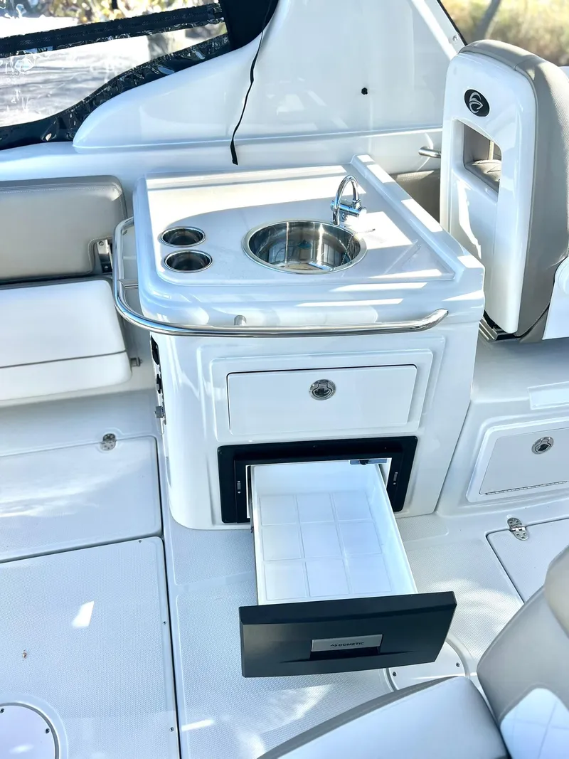 Slide: The Image of 2025 Crownline 280 DC boat interior with sink and storage drawer. - 45