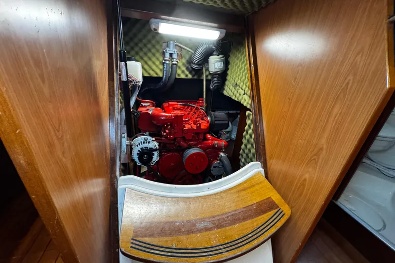 Slide: The Image of Engine compartment of 1999 Beneteau Oceanis Clipper 461 sailboat, featuring a red engine. - 109