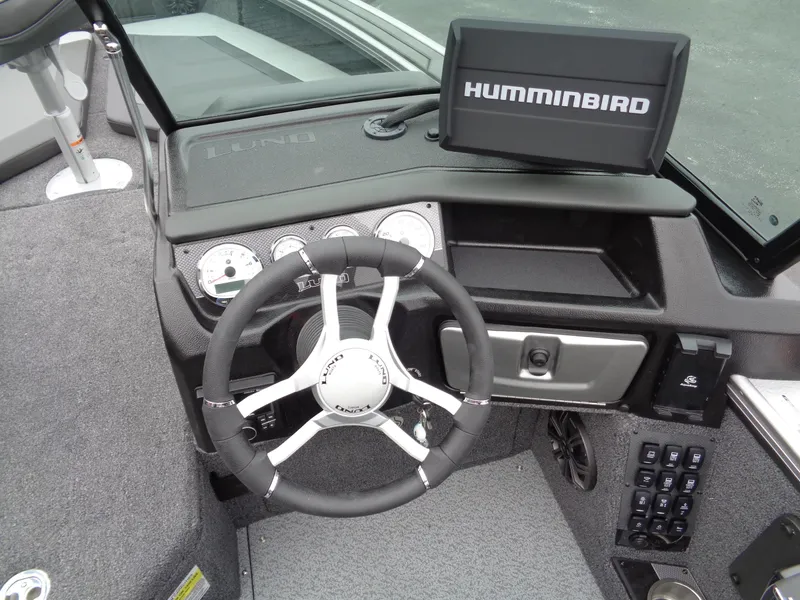 Slide: The Image of Lund 1975 Pro-V 2025 boat dashboard with Humminbird navigation system and steering wheel. - 26